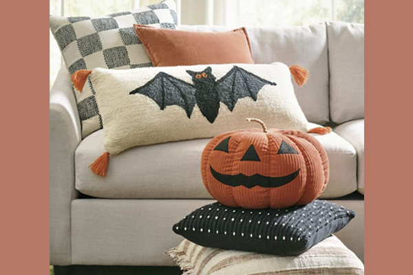 A close-up of Halloween pillows showing a color palette of orange, black, and white