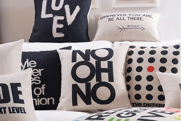 A collection of throw pillows with various typographic designs