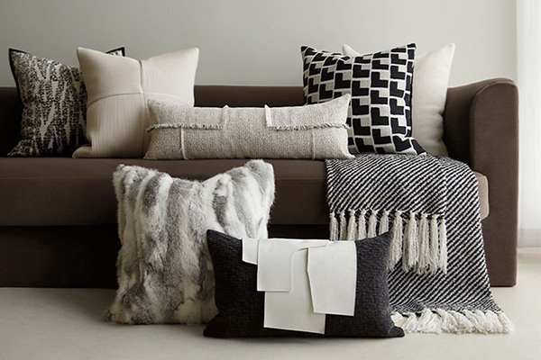 a variety of pillow shapes and sizes on a modern couch
