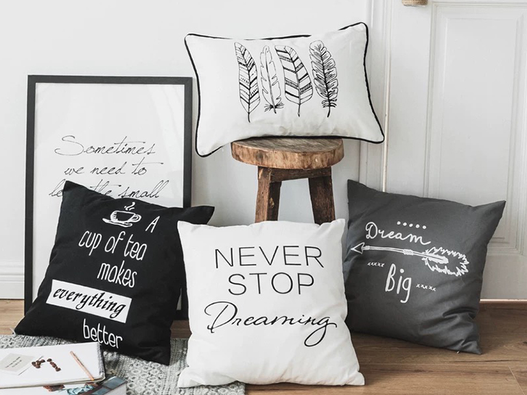 A styled couch with a curated collection of different typographic pillows
